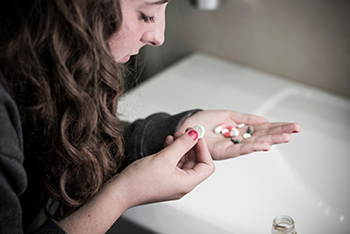 young woman taking pills